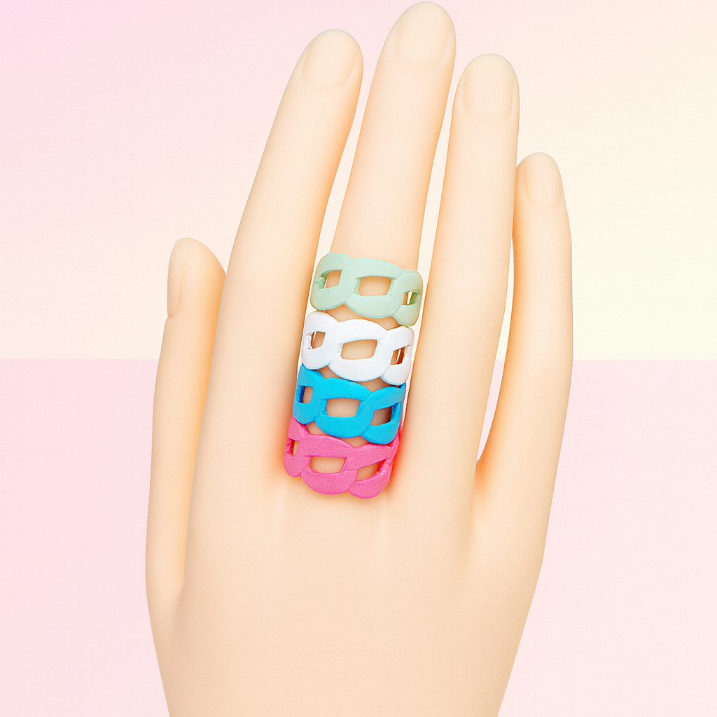 Colorful ring on a mannequin hand against a pastel pink background