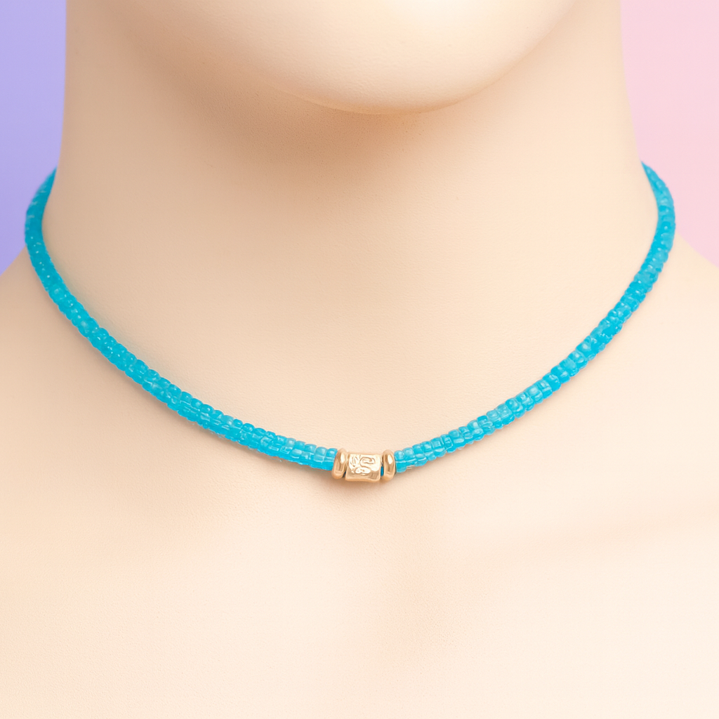 Turquoise beaded necklace with a gold clasp on a mannequin against a pastel background