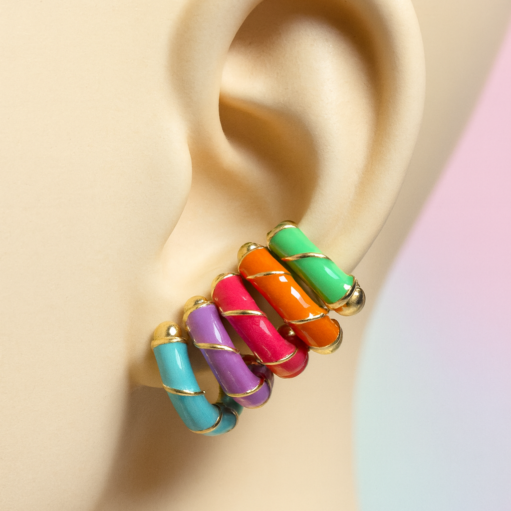 Multicolored ring earring on a model ear with a pastel background