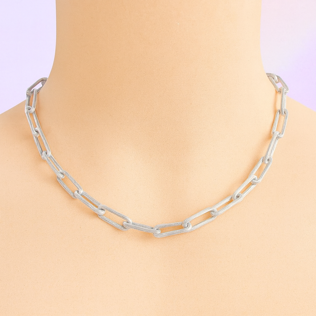 Silver chain necklace on a mannequin with a plain background