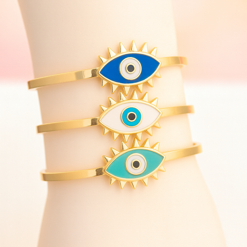 Set of gold bracelets with eye designs on a white background