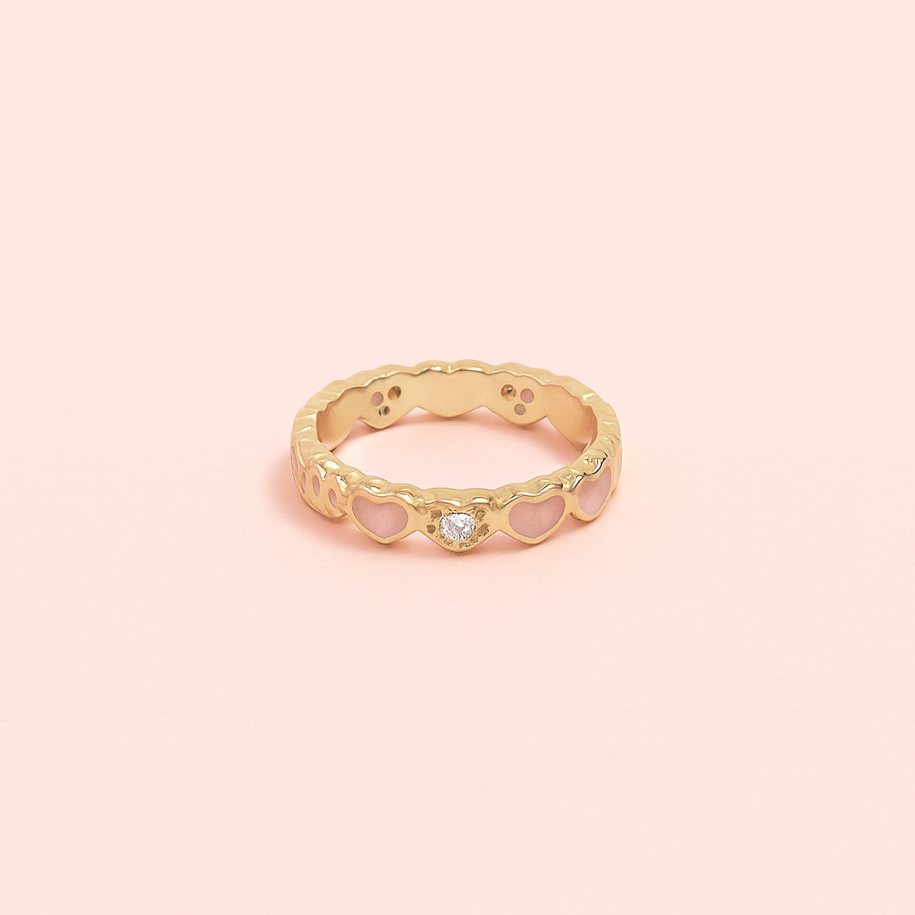 Gold ring with a diamond on a pink background