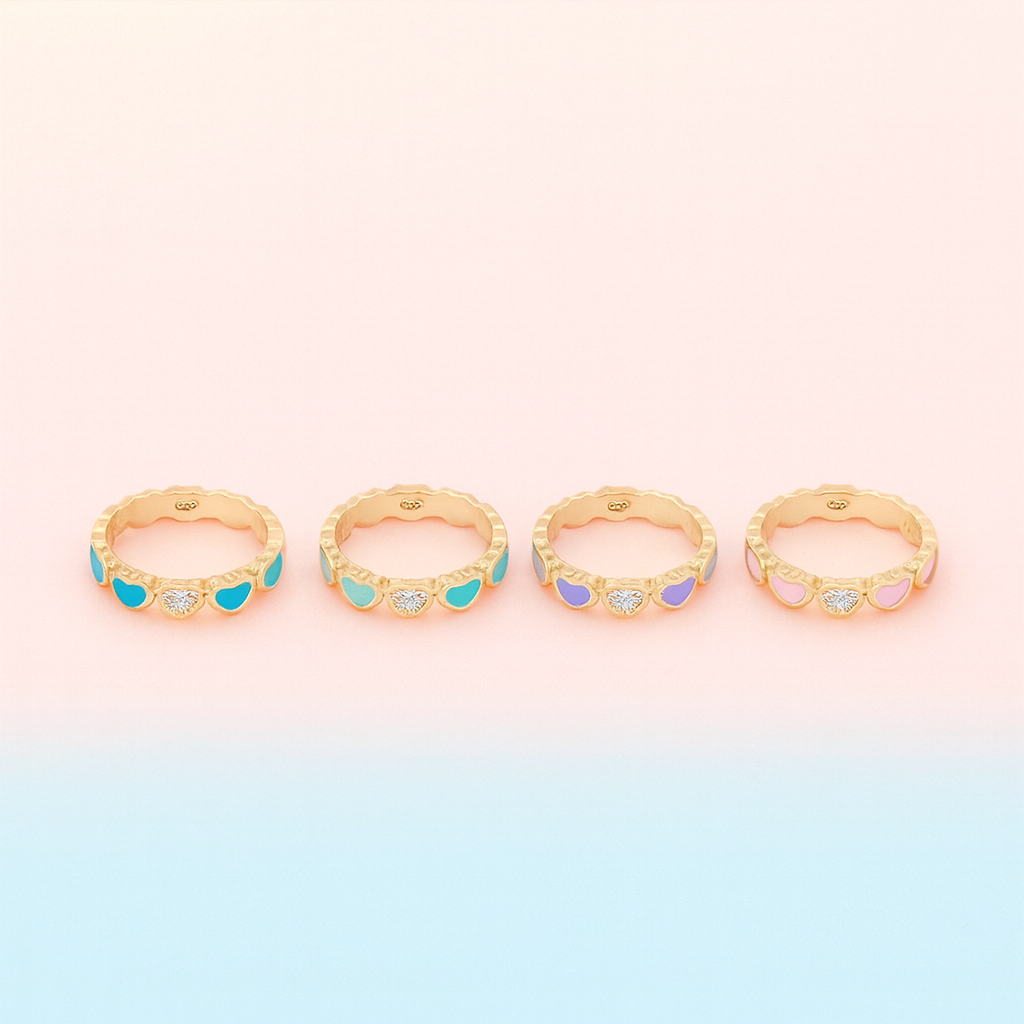Set of four gold rings with colorful gemstones on a gradient background