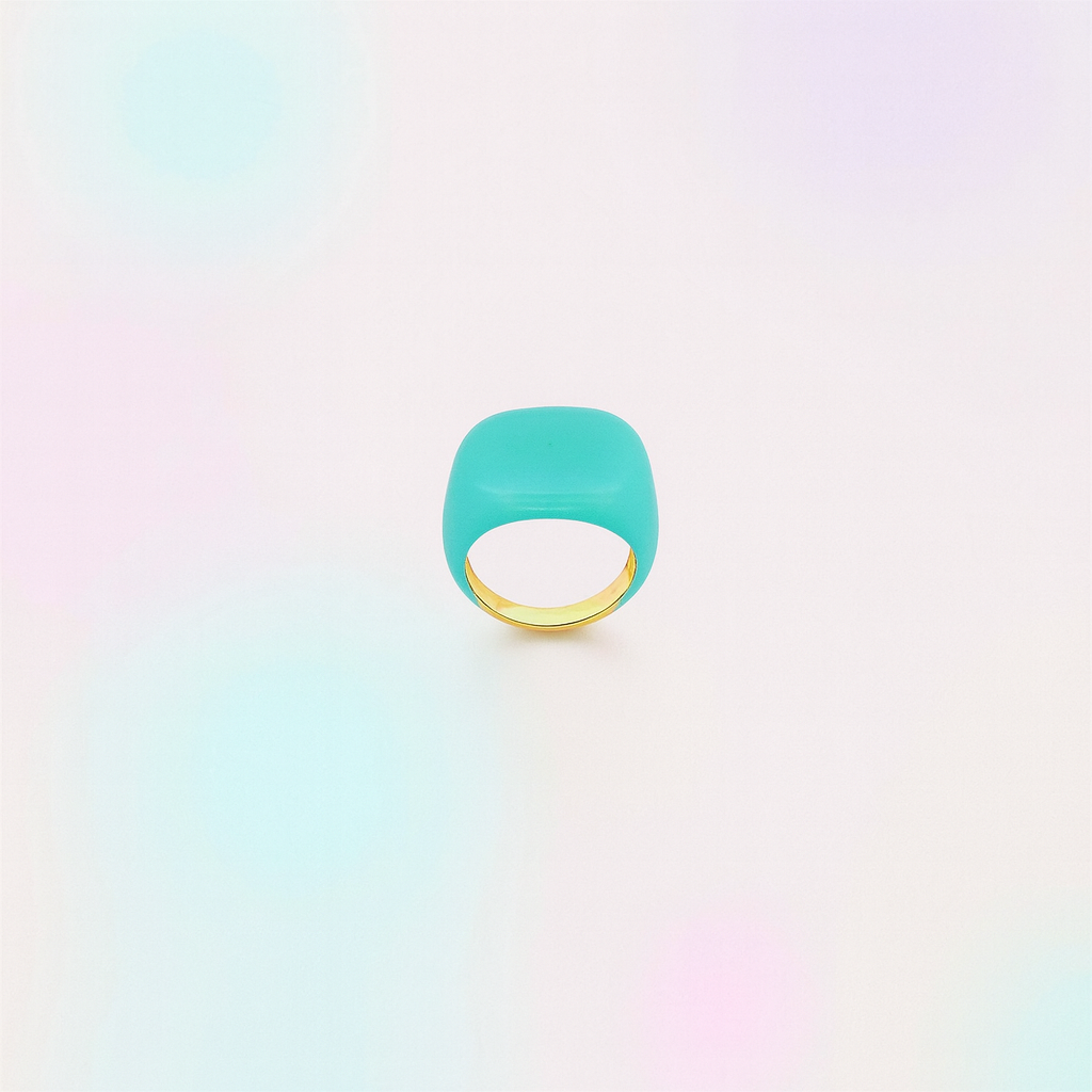 Turquoise ring with gold band on a gradient background