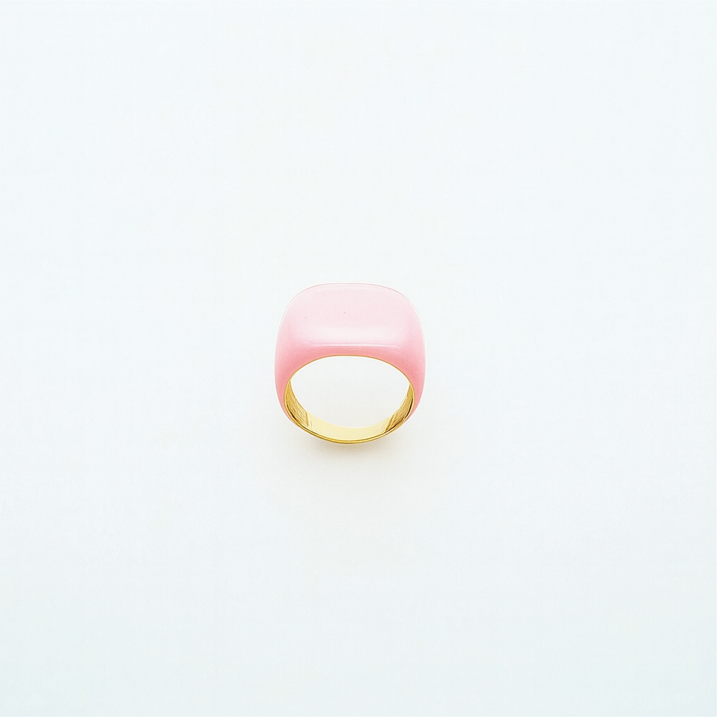Pink ring with gold band on a light gray background