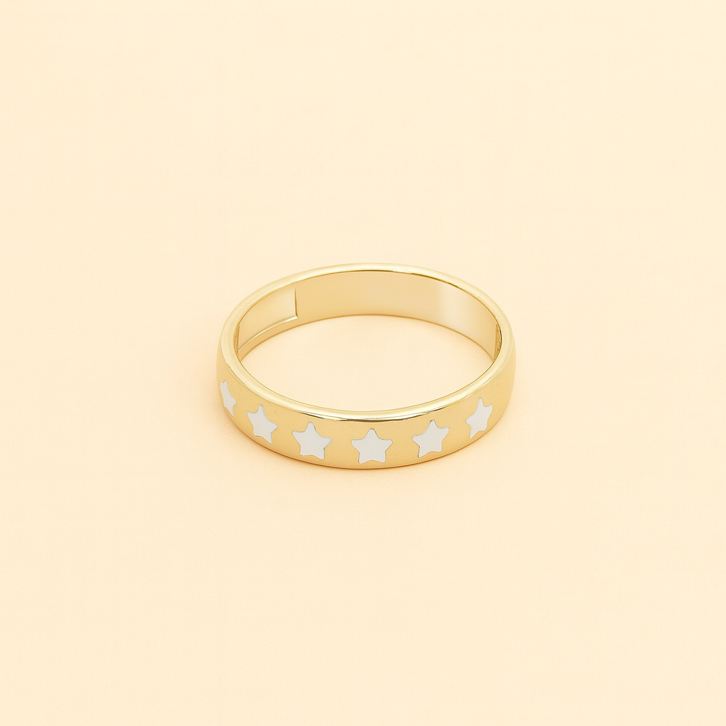 Gold ring with white star patterns on a beige background