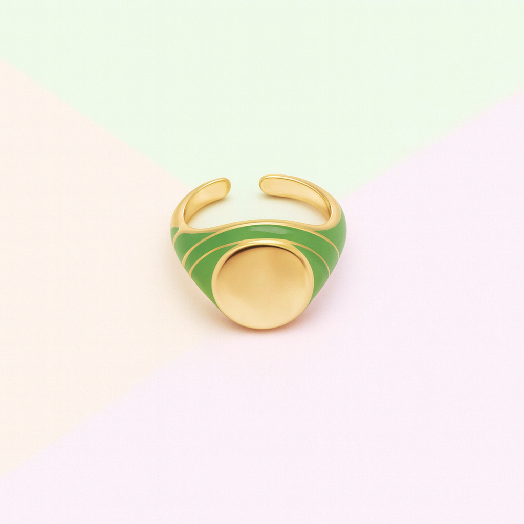 Gold and green ring on a light pink background