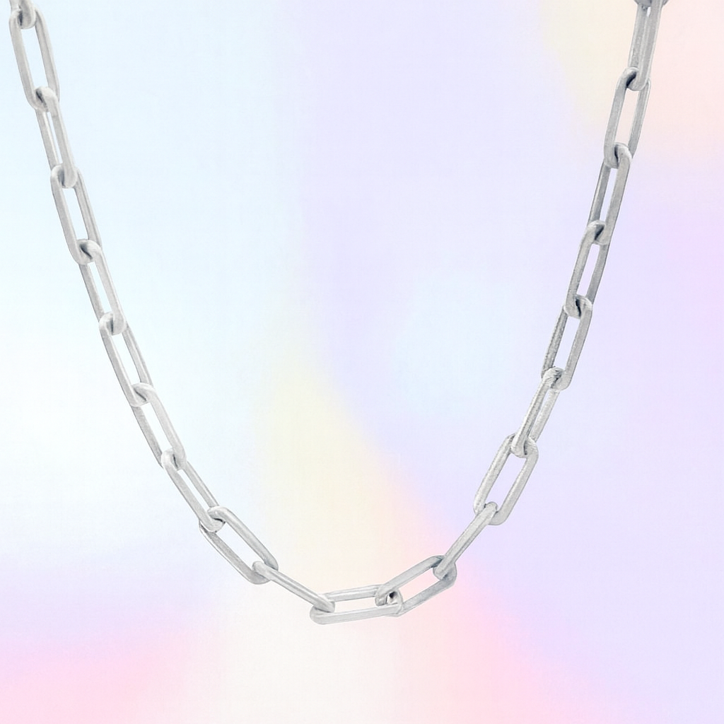 Silver chain necklace on a pastel gradient background