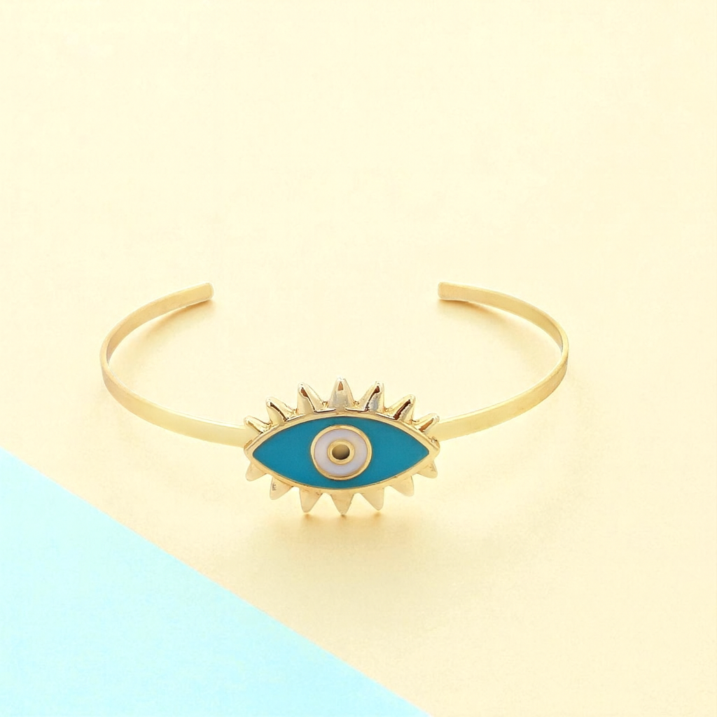 Gold bracelet with a blue evil eye design on a two-tone background