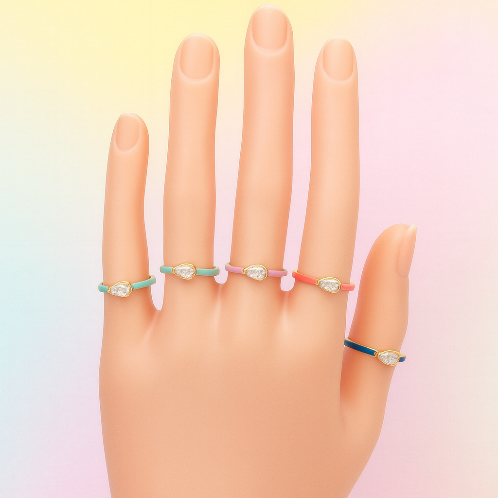 Hand wearing four colorful rings on a gradient background