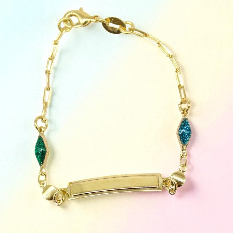 Gold bracelet with green and blue gemstones on a gradient background