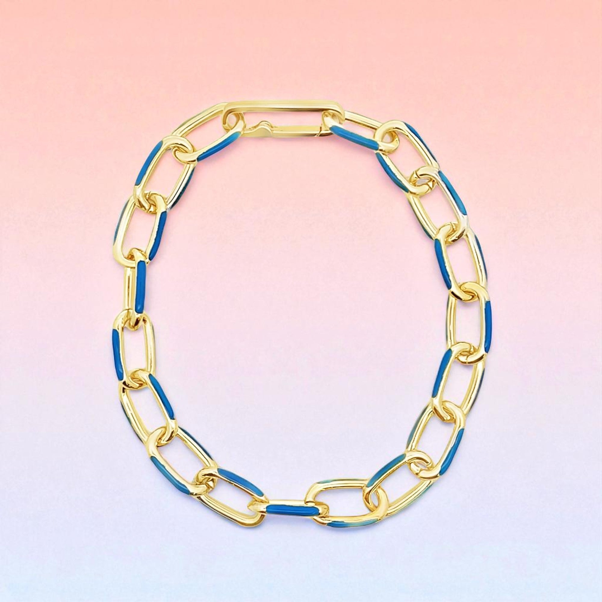 Gold and blue chain necklace on a gradient background